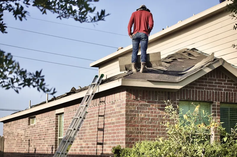 Professional roofer working on a residential roof in Glover
